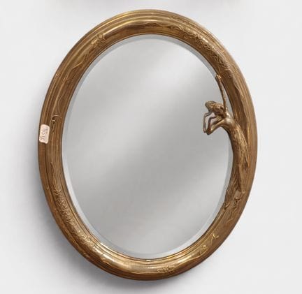 Miroir ovale en laiton ornée d'une figure de jeune