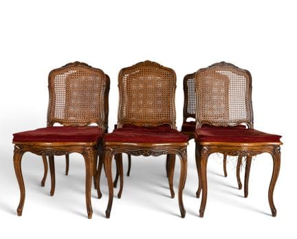 Set of six wooden cane-seated chairs with carved f