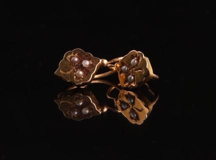 一对18K（750）黄金耳环，镶嵌小珍珠，饰有风格化的三叶草图案。
总重量：0.9克。