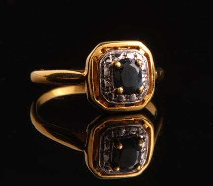 Gold-plated ring set with a dark blue stone and ac