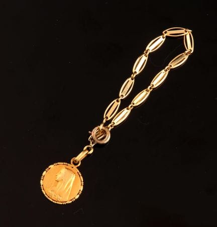 18K（750）黄金儿童手链，链身悬挂一枚饰有圣母玛利亚侧面肖像的吊坠。  
重量：3.4 克 
搭