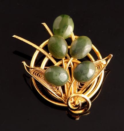 *A circular brooch made of gold-plated metal, shap