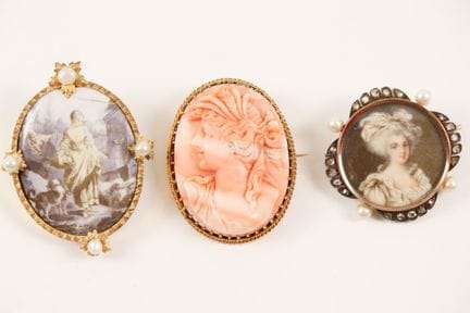 Three gold and enamel brooches featuring figures, 