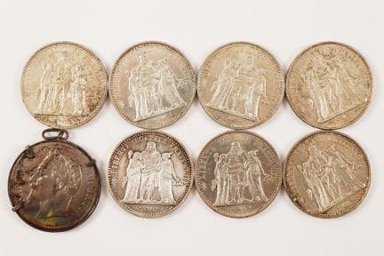 Eight silver coins: 
- 7 Hercules 10-franc silver 