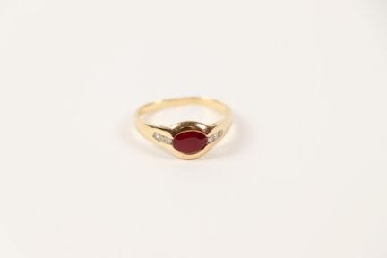 18K (750) gold ring set with a ruby and six small 