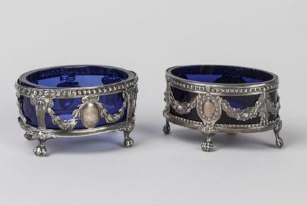 DOS SALEROS ovalados de plata cincelada, decorados