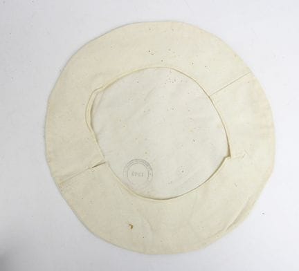 COIFFURES. Housse de béret en coton écru tamponnée