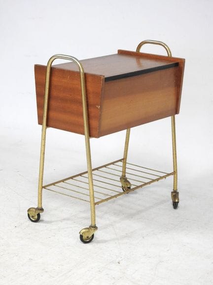 20世纪50年代的作品
一张工作桌，桌面为天然木皮材质，采用翻盖式设计，置于带滚轮的古铜色管状框架上