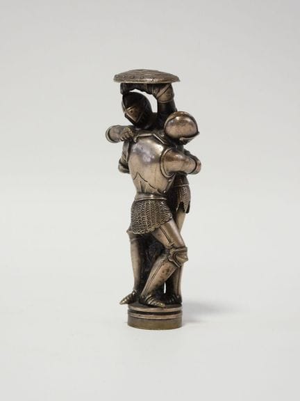 Sello neogótico de bronce plateado con una escena 