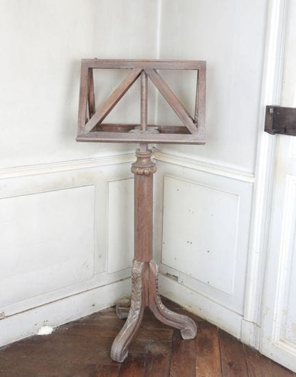 A molded and carved oak lectern resting on a tripo