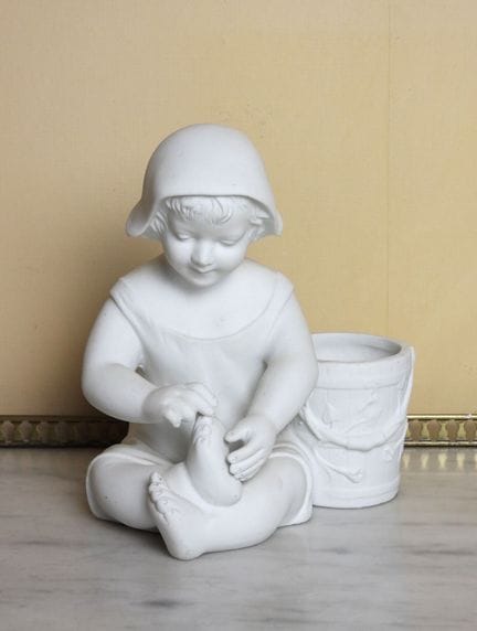 这件瓷器造型为花篮，描绘了一名手持水桶的小女孩。背面有“VM porcelaine de Franc