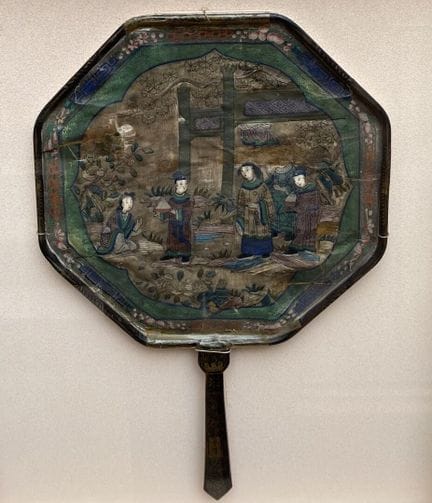 中国，广州——19世纪末
八角形扇，水粉画，绘于纸与布上，描绘了贵族与仆人在松树下的庭院中
24 x