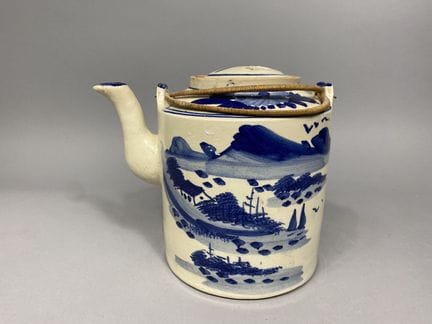 中国/越南 20世纪
大型奶油色陶瓷茶壶，饰有蓝色山水与枝叶图案
高：24.5 厘米