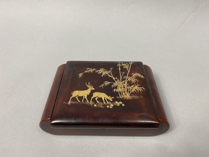 越南 20世纪
红色和金色漆面长方形木盒，饰有竹林下的一对鹿
5.5 × 19 × 15 厘米
（有