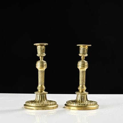 Ein Paar Kerzenhalter aus Bronze; sie stehen auf e
