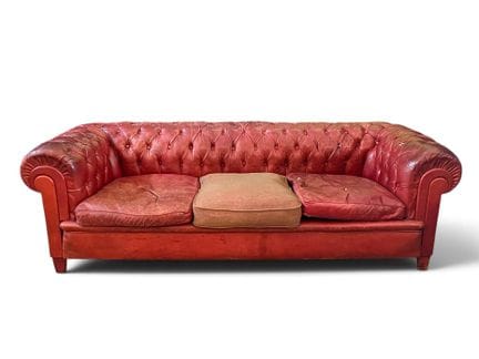 Sofá Chesterfield 

de cuero rojo
muy estropeado, 