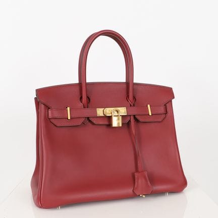 爱马仕 - Birkin 30
酒红色乔纳森小牛皮，配有铃铛、挂锁和钥匙。附带防雨罩。边角有使用过的