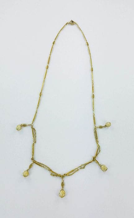 Collier draperie or garni de cinq perles dans des 