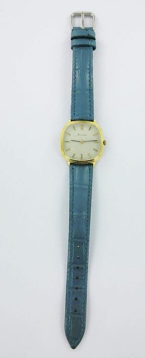 BULOVA。
750千分之一纯金腕表，配皮表带，白色表背，金属针扣，机械机芯。
毛重：32.1格拉