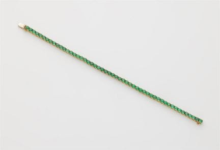 An 18k white gold and emerald rivière bracelet.

F