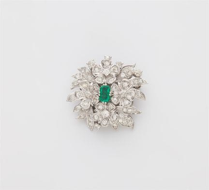 An 18k white gold diamond and emerald brooch made 