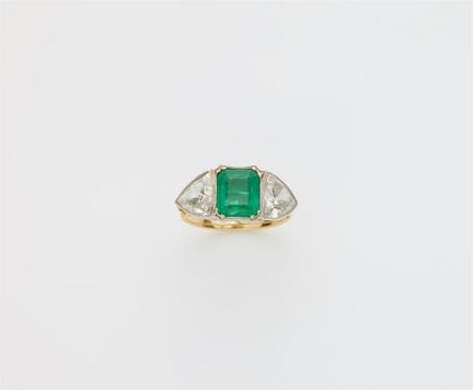 An 18k gold emerald and triangle-cut diamond three