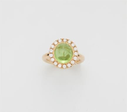 An 18k yellow gold diamond and peridot cabochon cl