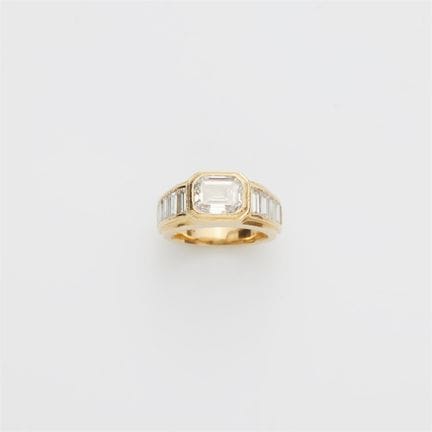 An 18k yellow gold diamond band ring with an emera