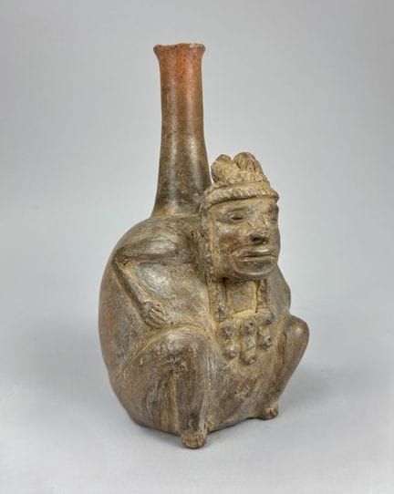 查文文化 - 秘鲁 - 公元前700年至400年
这件陶罐描绘了一位身着华丽服饰、呈蹲姿的人物。其身