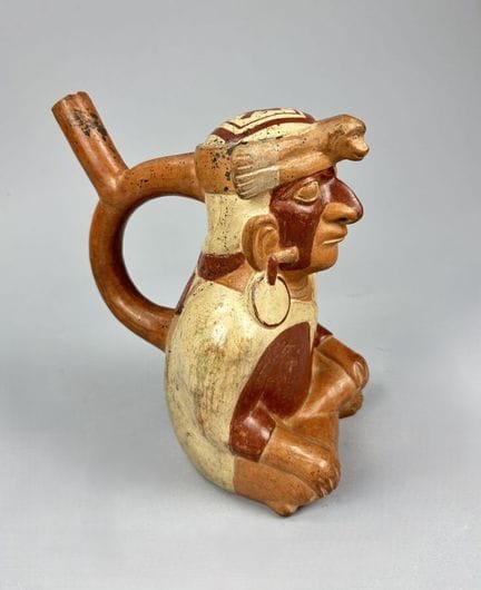 莫奇纳 - 秘鲁 - 公元500-600年
这是一款带有马镫形提手的花瓶，描绘了一位显贵人物。他盘腿