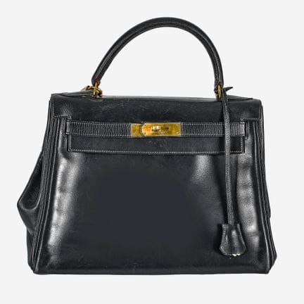 爱马仕（HERMÈS）：“凯莉包 28”手提包，1955年，
经典复古款式，采用海军蓝皮革制成。梯形