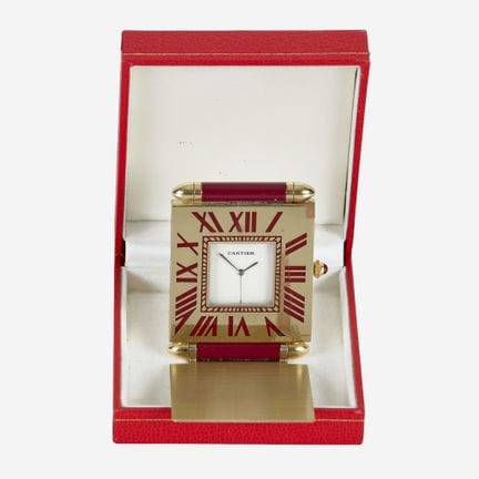 卡地亚（CARTIER）：台钟，约1980-1990年，
可翻盖式镀金金属表壳，饰有红色漆面。表冠镶