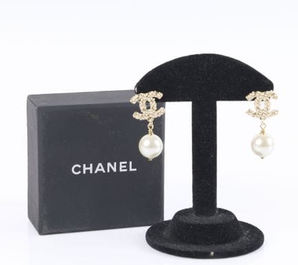 CHANEL. Par de pendientes de metal dorado con el l