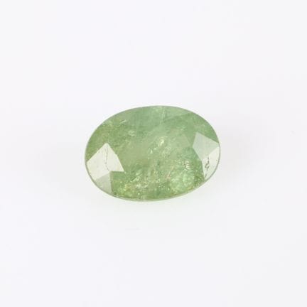 Granate oval demantoide andradita sobre papel con 