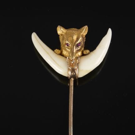 金质狩猎胸针，狐狸头顶镶嵌着小颗红色宝石，下方是两颗狐狸牙。
19世纪末。
宽27毫米。总重8.47