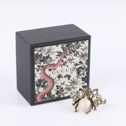 GUCCI. Broche de metal dorado con forma de abejas,