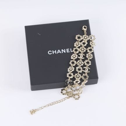CHANEL. Pulsera articulada de metal dorado con str