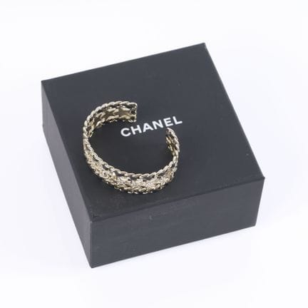 CHANEL. Pulsera tipo medio brazalete de metal dora