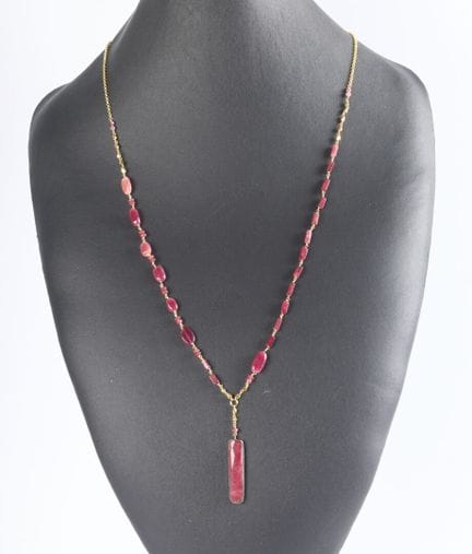 Collar largo de metal dorado adornado con piedras 