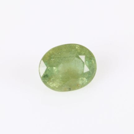 Granate oval demantoide andradita sobre papel con 