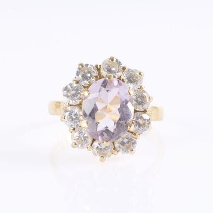 Anillo de oro con una piedra violeta engastada y r
