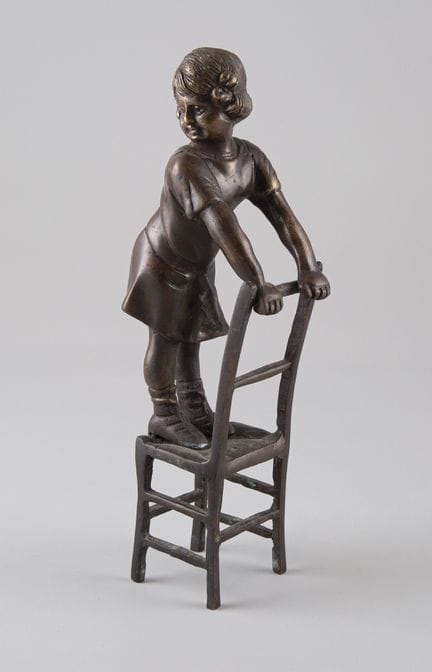 Copia en bronce que representa a una niña sentada 