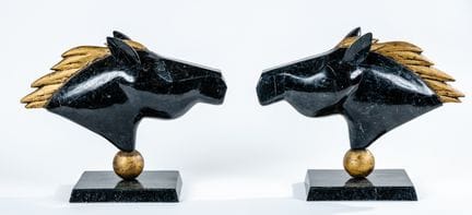 一对马头雕塑，采用仿大理石的黑色树脂贴面制成，马鬃为金色。20世纪末的装饰艺术作品。高度：32厘米。