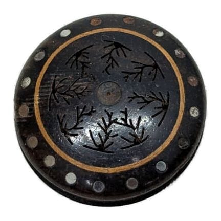 A dark wood scent box; the top is adorned with eng