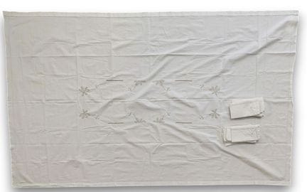 Une nappe blanche brodée et ajourée avec onze serv