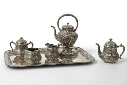 一套五件式纯银茶具，包括：两只茶壶（其中一只配有暖壶）、一只带盖的糖罐、一只奶壶和一只茶杯，全部饰有