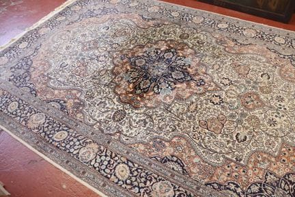 Alfombra de lana con fondo beige y motivos florale