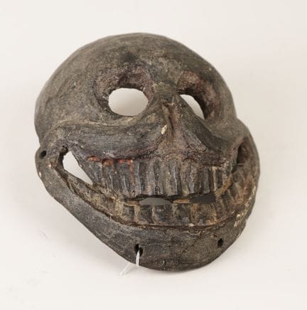 A mask with a grimacing expression reminiscent of 