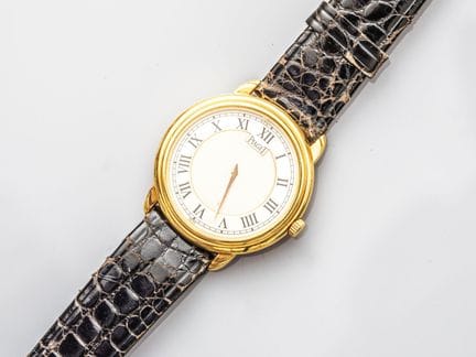 PIAGET，中号圆形表壳腕表，采用750°/°°（18K）黄金材质。白色与银色表盘，配罗马数字时标