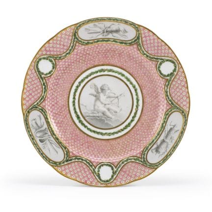 塞夫勒瓷器厂，约1770年。 一只彩绘瓷盘，采用灰调画法，在月桂叶花冠构图的镶框内描绘了小天使和战利